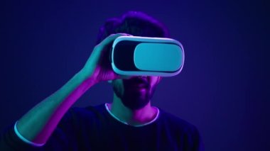 Metaverse sanal gerçeklik siber uzayı Wonder Man 'in VR gözlüklerini oyun sonrası kaskını çıkarmasına şaşırdı. Meta evren dijital teknolojiyi tecrübe etti. Neon ultraviyole fütüristik uzayda siber oyuncular heyecanlandı.