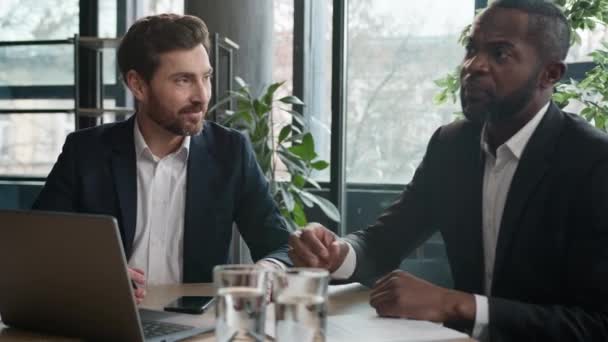 多様な男性の同僚ビジネスパートナー2つの多人種間のビジネスマン感情的な議論プロジェクトをオンラインスタートアップノートパソコン白人男性署名契約書ノートを書くことオフィスで保険投資販売 — ストック動画