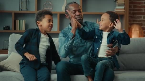 Afrikansk Amerikansk Far Med Telefon Hemma Soffa Med Två Pojkar — Stockvideo
