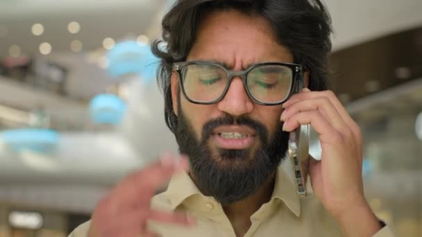 心配深刻なインドのビジネスマンを閉じますメガネでイスラム教徒の経営者アラビア語の経営者起業家の男は携帯電話のビジネスの話の会話の問題を話すコール交渉 — ストック動画