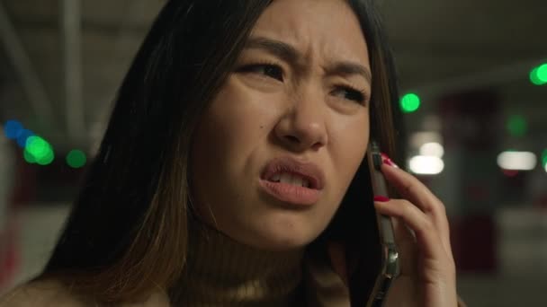 忧心忡忡的失望女孩亚裔华裔日本女商人在地下停车场打电话给手机交谈智慧电话问题沮丧的女人说话解决问题失败的负面情绪 — 图库视频影像