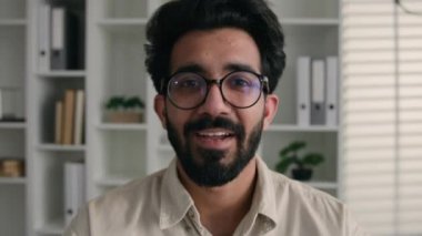 Webcam görüntüsü mutlu Arap Hintli Müslüman adam gözlüklü erkek öğretmen öğretmen iş adamı bilgisayar kamerasında gülümseyen video görüntülü eğitim kursunda iş görüşmesi yapıyor.
