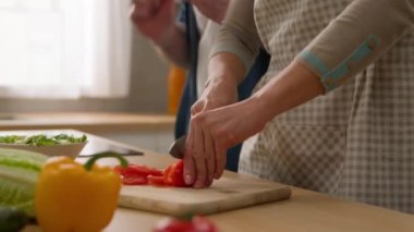Beyaz kadın, taze sebze salatası pişiriyor. Kocasıyla domates dansı yapıyor. Kocasıyla neşeli dans ediyor.