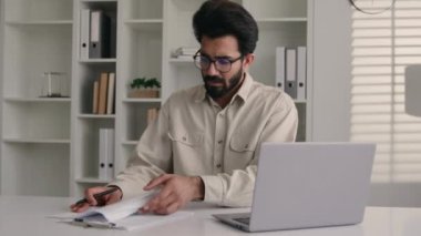 Stresli erkek müslüman işadamı Arap Hintli üzgün girişimci ofis çalışanı iş belgeleriyle çok çalışıyor finansal sorun borç batması dizüstü bilgisayar hatası