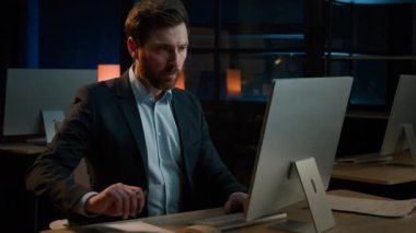 Orta yaşlı iş adamı Kafkasyalı yetişkin muhasebeci sigorta belgeleri yazma iş planı bilgisayardaki arama verileri akşam karanlık ofis işyerinde fikir notları yazma