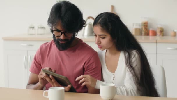 多様な男性と女性は 電子タブレットPcを使用していますEコマースアプリのウェブ上でデバイスの画面ショッピングを見て多人種のアラビア語のイスラム教徒のカップルは インターネット上で商品を選択簡単に注文キッチンでの食品配達 — ストック動画