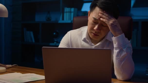 アジア人は疲れを強調韓国人中年疲れ過労ビジネスマンのラップトップ作業の問題書類作業の問題ビジネストラブル悪い結果文書夜のオフィスでの障害ストレス — ストック動画