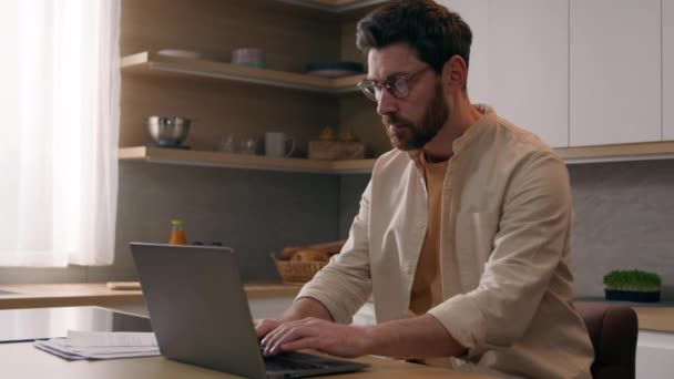 白种人 忙碌的自由职业者 在远离家的地方工作 带着笔记本电脑 在厨房里疲惫不堪的生意人摘下眼镜 眼睛因电脑干了而痛苦不堪 — 图库视频影像