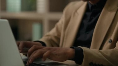 Bilgisayarda dizüstü bilgisayarda klavye yazan erkek eli hareket ediyor. Afrikalı Amerikalı erkek, etnik erkek, ceo iş adamı. Ofiste çalışan gülümseyen ofis müdürü.