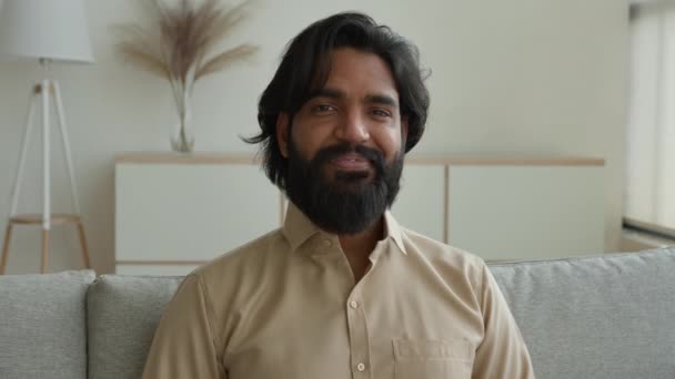 幸せな笑顔髭を生やした男イスラム教徒中東アラブ人男インド人男性実業家リビングルームの自宅のオフィスの肖像画大人のフリーランスの家の所有者は カメラの笑顔を見てアパートを借りる — ストック動画