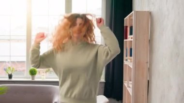 Aktif, beyaz kız mutlu, heyecanlı kadın dans eden, otel odasındaki rahat yatakta zıplayan, sabah keyfi yapan, eğlenen, müzik partisinde zıplayan, kazanan.