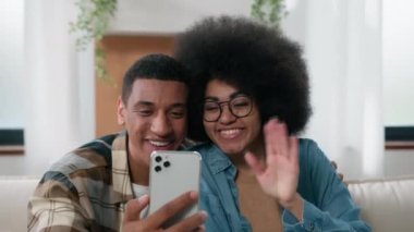 Afro-Amerikalı mutlu çift gülüyor. Güzel sohbetler. Sanal görüntülü konuşma. Cep telefonu konferansı.
