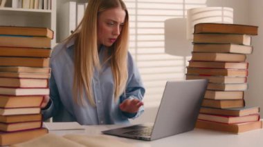 Stresli, sinirli, Kafkasyalı, liseli kız öğrenci, stresli, dizüstü bilgisayar ve kitap ödevi hazırlayan, online arama bilgileri öğrenme zorluğu çeken sınavlar.