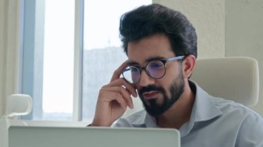 Düşünceli düşünceli Arap iş adamı pazarlama yöneticisi ofiste bilgisayar çalışıyor Hintli müslüman girişimci online iş projesini analiz etmeyi düşünüyor problem çözümü beyin fırtınası