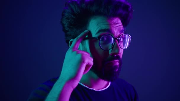インド人開発者コーディング労働者コンピュータースマートなハッカーで眼鏡ネオン紫外線スタジオ背景ハード脳力を考える精神力それについて考える問題解決Iqジェスチャー — ストック動画