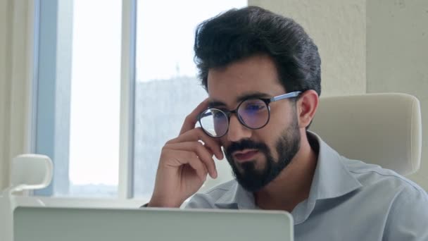 オフィスでコンピュータを操作する思考の集中的なアラビアのビジネスマンのマーケティングマネージャーインドのイスラム教徒の男性起業家オンラインビジネスプロジェクトを分析する思考は 問題解決のブレインストーミングを考える — ストック動画