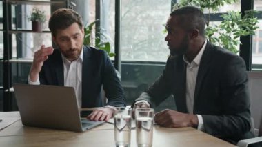 İki farklı işçi erkek çok ırklı ortaklar ofis iş arkadaşları evrakları ve dizüstü bilgisayarları olan üzgün iş adamları bilgisayar projesi zorluklarını tartıştılar.