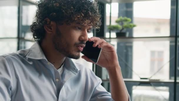 匿名のインドのビジネスマンストレスの多い男がオフィスで電話でビジネスディスカッションを口論アラビア人男性の叫びは 紛争を解決します男性不満のある従業員が大声で録音音声メッセージを話して — ストック動画