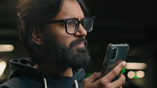 可悲的穆斯林男子在手机上读到的消息让人心烦意乱的坏消息令人困惑的戴眼镜的阿拉伯男子与智能手机的通知印度用户认为手机在停放方面有困难 — 图库视频影像