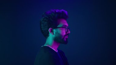 Hintli ciddi adam portresi. Kodlama işçisi profili. Baş internet teknolojisi hacker erkek. Mavi ultraviyole fotoğraf stüdyosu arka planında yüksek teknoloji siber uzay.