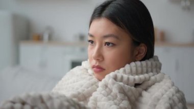 Üzgün Asyalı kadın evde yalnız başına, sıcak battaniyeyi sarmış derin düşüncelere dalmış depresyon, düşünceli, hasta Çinli, yalnız, Koreli kadın üzgün, hüzünlü, kederli, kederli, melankolik, kederli, kederli bir kadın.