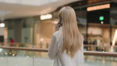 Kafkasyalı kadın telefonla konuşuyor. İş kadını, alışveriş merkezi müşterisi kaygısız. Ofiste modern alışveriş merkezinde arkadaşlarıyla sohbet ediyorlar.