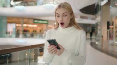 Kafkasyalı kadın müşteri müşterisi gen z kullanıcısı sosyal medya aleti bağımlısı mutlu kız, alışveriş merkezinde akıllı telefon tavsiyesiyle cep telefonu işaret parmağıyla inanılmaz bir sürpriz kazandı.