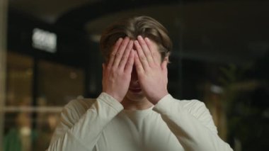 Kafkasyalı hasta bir adam baş ağrısı çekiyor. Baş ağrısı çekiyor. Erkek öğrenci masajı yapıyor. Kramp, migren yüksek tansiyon, yüksek tansiyon hastalığı.