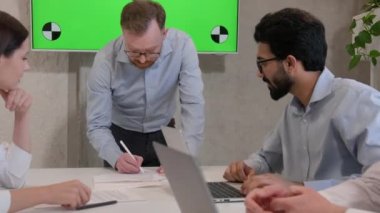 Çok ırklı iş adamları iş kadınları, iş adamları, şirket iş görüşmeleri, takım liderleri, interaktif yeşil ekran kroma anahtar kopyalama alanı ile ofis toplantısında belge anlaşması imzalarlar.