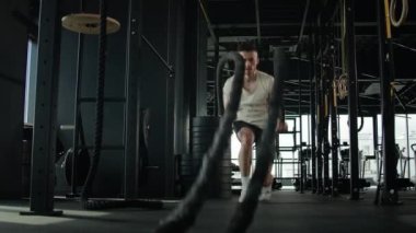 Aktif kas sporcusu Kafkas sporcusu spor adamı spor salonunda antrenman yapıyor ağır savaş ipleriyle çömeliyor yoğun egzersiz sporu vücut geliştirme iyi fiziksel ve sağlıklı bir yaşam tarzı sağlıyor.