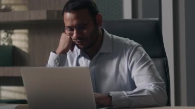 Uyuklayan tembel yetişkin Hintli adam Arap iş adamı Amerikan yönetici ofis çalışanı bilgisayardan sıkıldı akşam son teslim tarihi iş adamı yorulmadı aşırı yorgunluk esneme