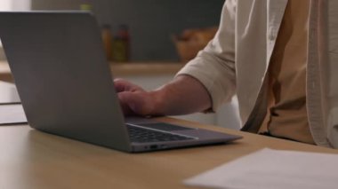 Beyaz tenli serbest çalışan bir adam, ev sahibi olan bilgisayarcı adamla internetten uzak çalışıyor. Gözlükleri çıkarıyor. Evrak harcamalarını kontrol ediyor.