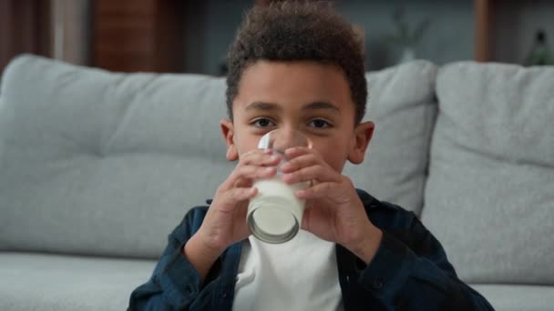 头部近距离拍摄肖像画 10岁的小男孩笑着在家里喝牛奶 用弯曲的牙齿拍照 非裔美国人儿子喝着一杯甜有机酸奶快乐的微笑 — 图库视频影像