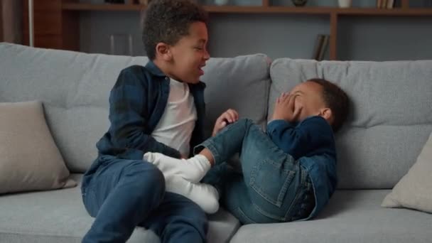 Dos Hermanos Afroamericanos Niños Jugando Divertirse Sofá Haciendo Cosquillas Hablando — Vídeo de stock