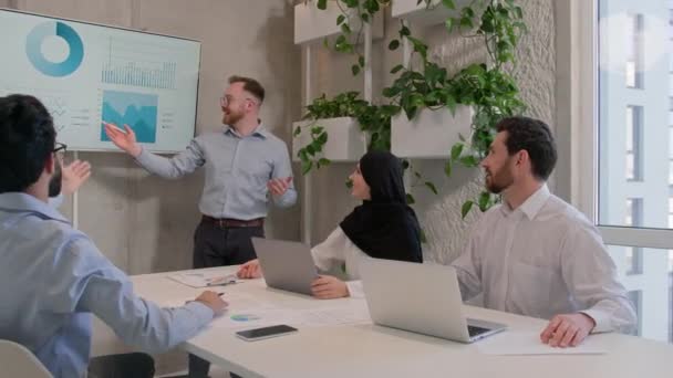팀장은 사무실 동료들에게 비즈니스 프로젝트에 설명하고 쌍방향보드 사업가 회의에 그래프 — 비디오