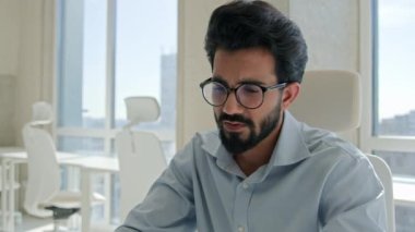 Yorgun ve stresli Arap erkek Hintli erkek işadamının dizüstü bilgisayarında iş sorunu var. Yorgun Müslüman adam, borç eksikliğinden endişeleniyor. Evrak işleri stresten patlak vermekte zorlanıyor.