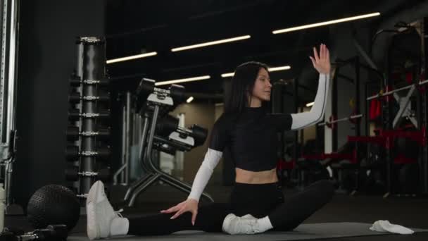 白种人女体形瘦弱的女运动员训练侧弯运动积极运动的女健身教练练习普拉提伸展到地面瑜伽练习伸展身体倾斜模糊镜头 — 图库视频影像