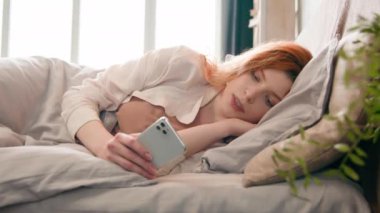 Kafkasyalı kadın yatakta rahatlamış akıllı telefonlu telefonda sohbet ediyor sosyal medya kontrolü geç saatte acele işe koşun sabah geç saatte geç saate kadar çalışan alet bağımlısı toplantı