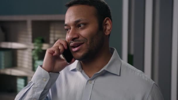 インド人の笑顔の男アラビア人ビジネスマンオフィスで携帯電話を話すアメリカ人起業家マネージャー明るい雇用主職場でスマートフォンの呼び出しを話す幸せな労働者携帯電話を話す — ストック動画