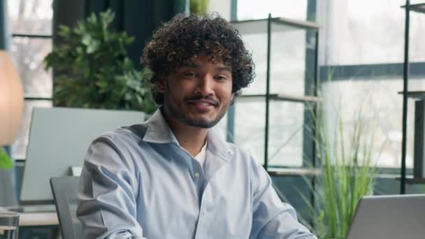 印度快乐男人阿拉伯裔商人微笑雇员企业家经理用笔记本电脑看相机微笑展示大拇指的好结果商业成就批准办公室工作 — 图库视频影像