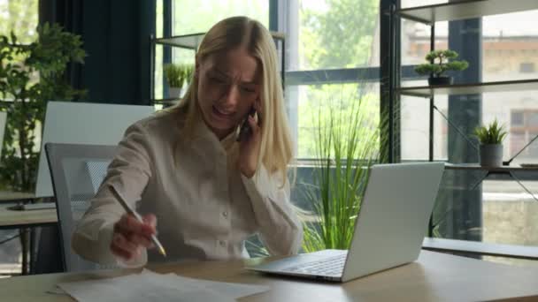 マルチタスク白人のビジネス女性は 携帯電話のビジネスの呼び出しを話す怒っているストレスの女性の女の子はオフィスで過労ノートパソコンを書きます負の結果は ストレスを主張紛争の問題を解決 — ストック動画