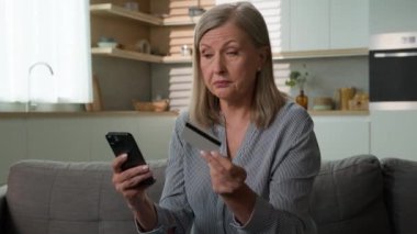 Kafası karışmış Kafkasyalı kadın kredi kartı tutuyor ev telefonuyla ödemeyi denerken başarısız online ödeme reddedildi banka dolandırıcılık veri hatasında yetersiz fon