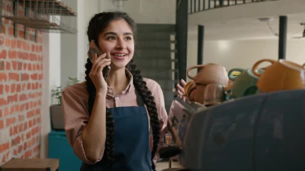 Lachende Indiase Vrouwelijke Barista Serveerster Schort Praten Telefoon Achter Cafetaria — Stockvideo