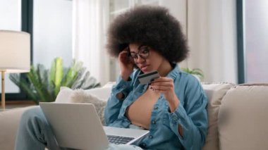 Afro-Amerikalı üzgün bir kız, kaynak yetersizliğinden hayal kırıklığına uğradı, kredi kartı ödemeleri online kredi kartı sorunları, internet alışveriş iflası, dizüstü bilgisayar kullanımı, ev dolandırıcılığının önünü tıkadı.