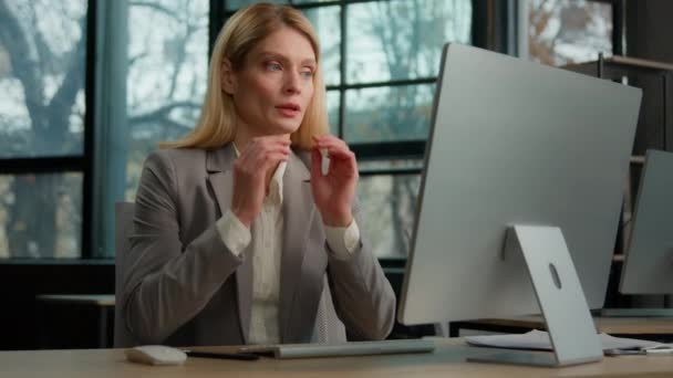 疲れて白人の大人40代の女性労働者のビジネス女性はオフィスのコンピュータとのオンライン仕事で一時停止する痛みを伴う頭痛片頭痛を感じる パソコンの働き過ぎは痛みを感じる — ストック動画