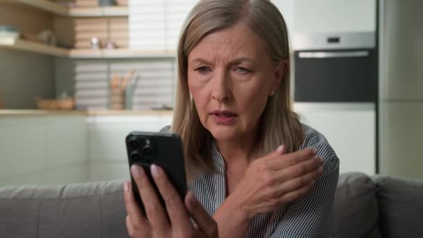 Bekymret Frustreret Senior Kvinde Læser Dårlige Nyheder Mobiltelefon Chokeret Ældre – Stock-video