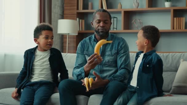Афроамериканська Сім Двома Дітьми Батько Який Розмовляє Дітьми Дає Бананам — стокове відео