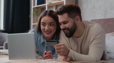 Kafkas ailesi mutlu çifti karı koca internet üzerinden alışveriş yapıyor karı koca banka kredi kartıyla sipariş dağıtım hizmeti alıyor para bankacılığı uygulamasını dizüstü bilgisayara harcıyorlar