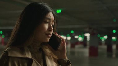 Endişeli Asyalı kadın park yerinde cep telefonuyla konuşuyor endişeli endişeli konuşuyor hayal kırıklığına uğramış akıllı telefon görüşmesi Çinli Koreli kız konuşuyor endişeli, sıkıntılı kötü haber