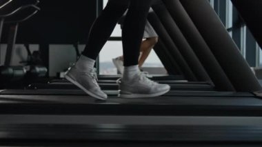 Koşu bandında koşan sporcu kadınlar spor ayakkabısı giymiş kadın koşucu ayakları spor makinesinde spor jimnastik egzersiz, koşu, hızlı koşu, sağlıklı yaşam tarzı.
